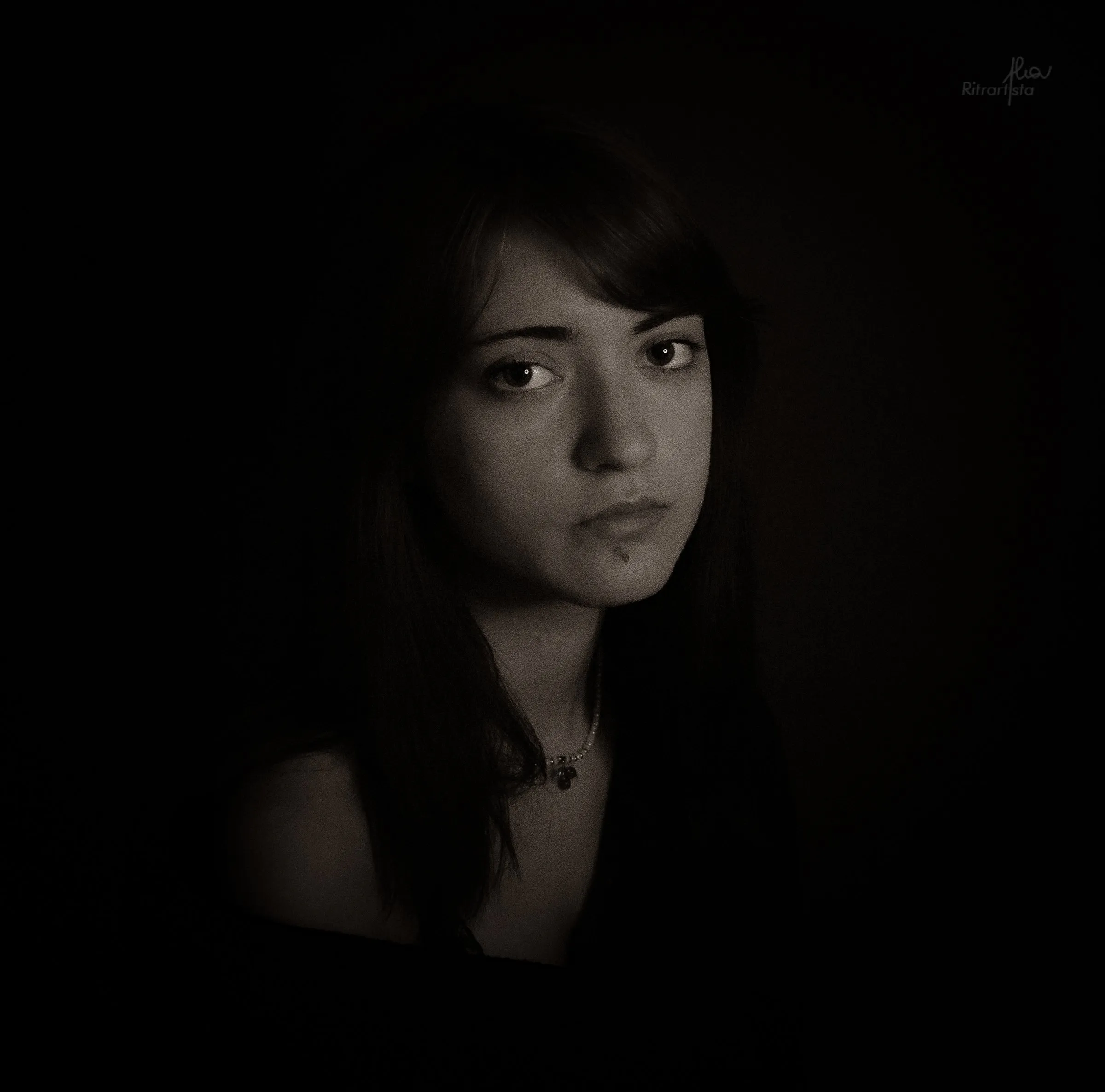 Ritratto intimo in penombra, sguardo di lato