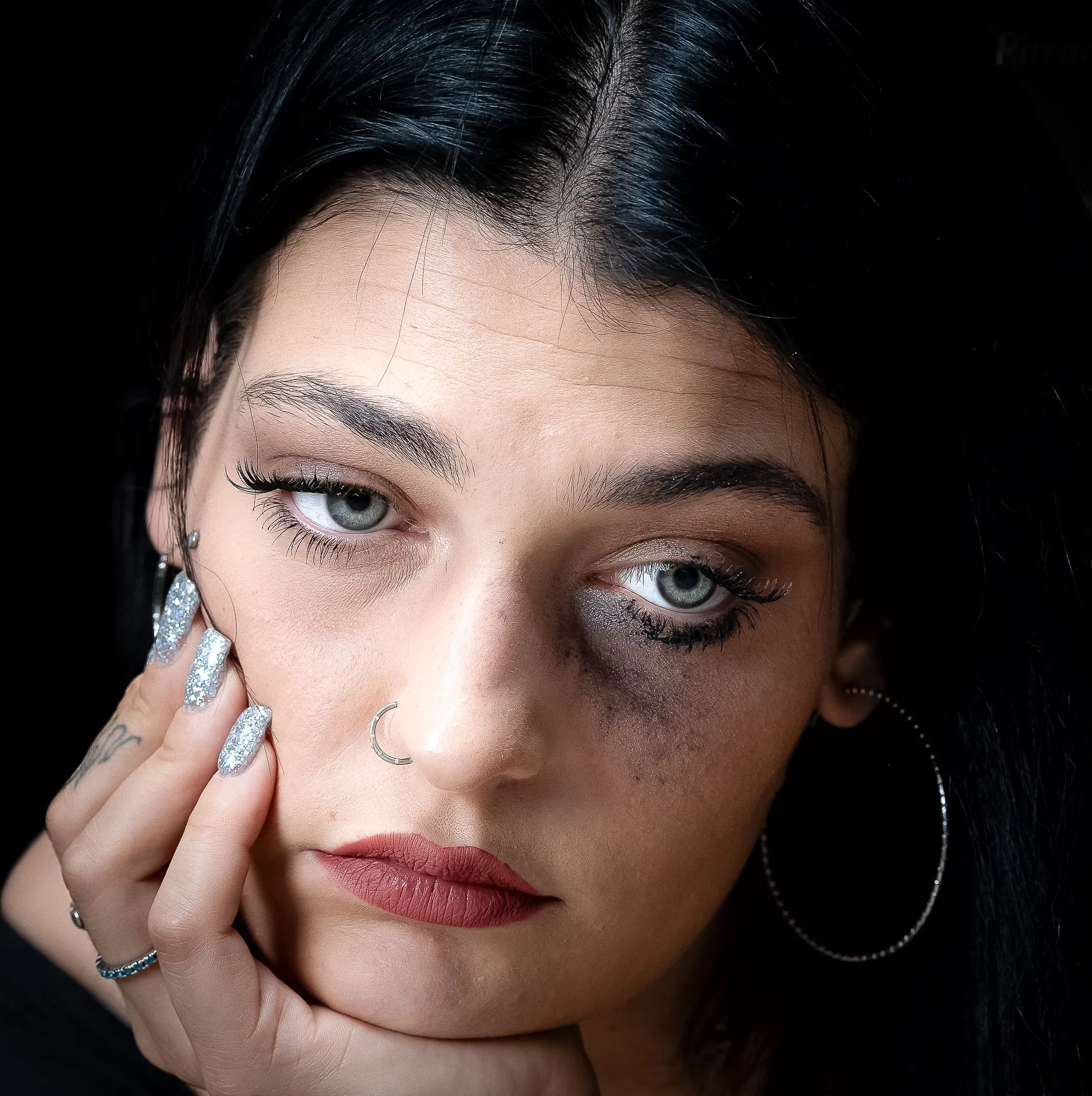 Giovane donna con orecchini a cerchio, sguardo diretto
