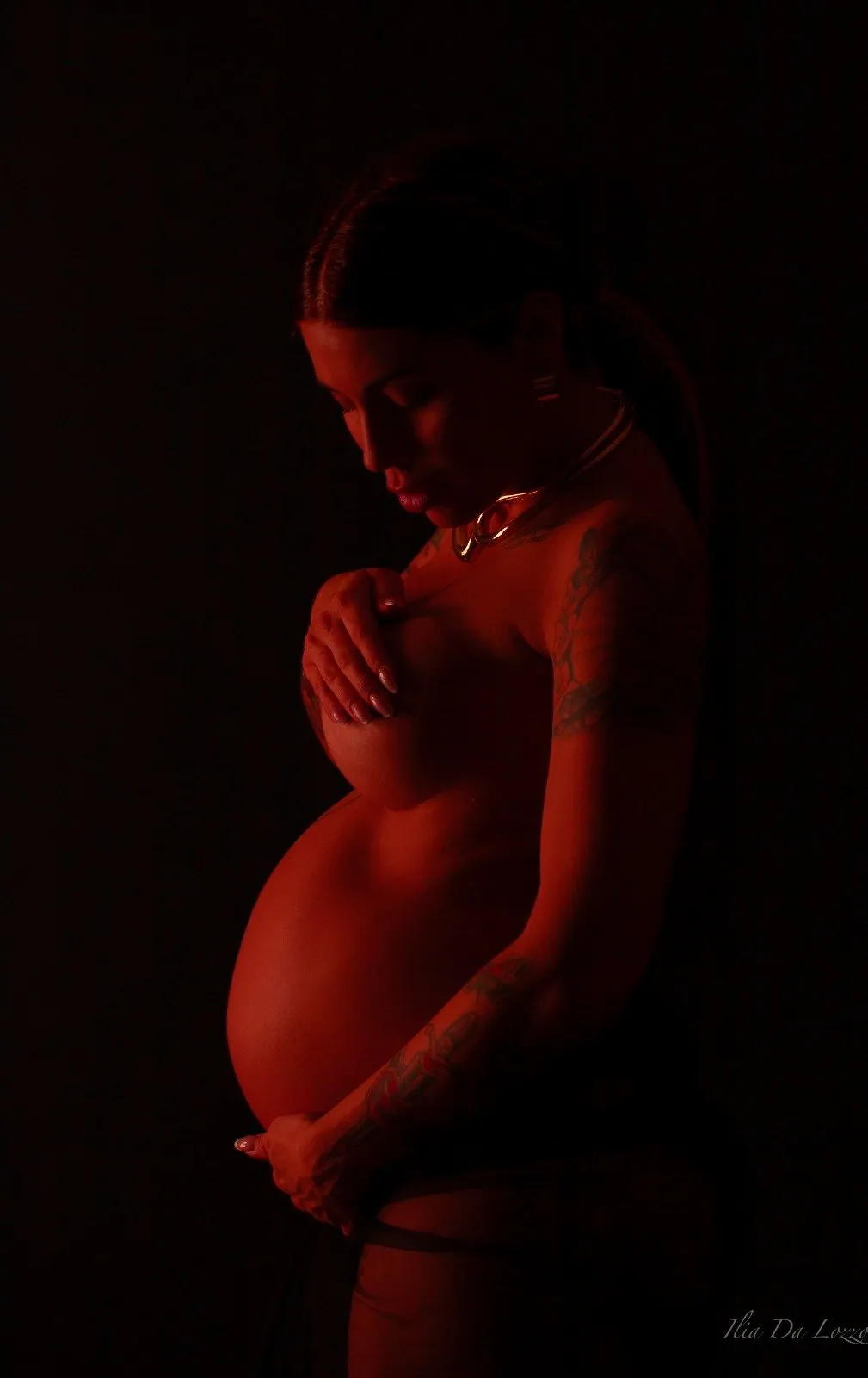 Maternity in luce rossa su fondo nero