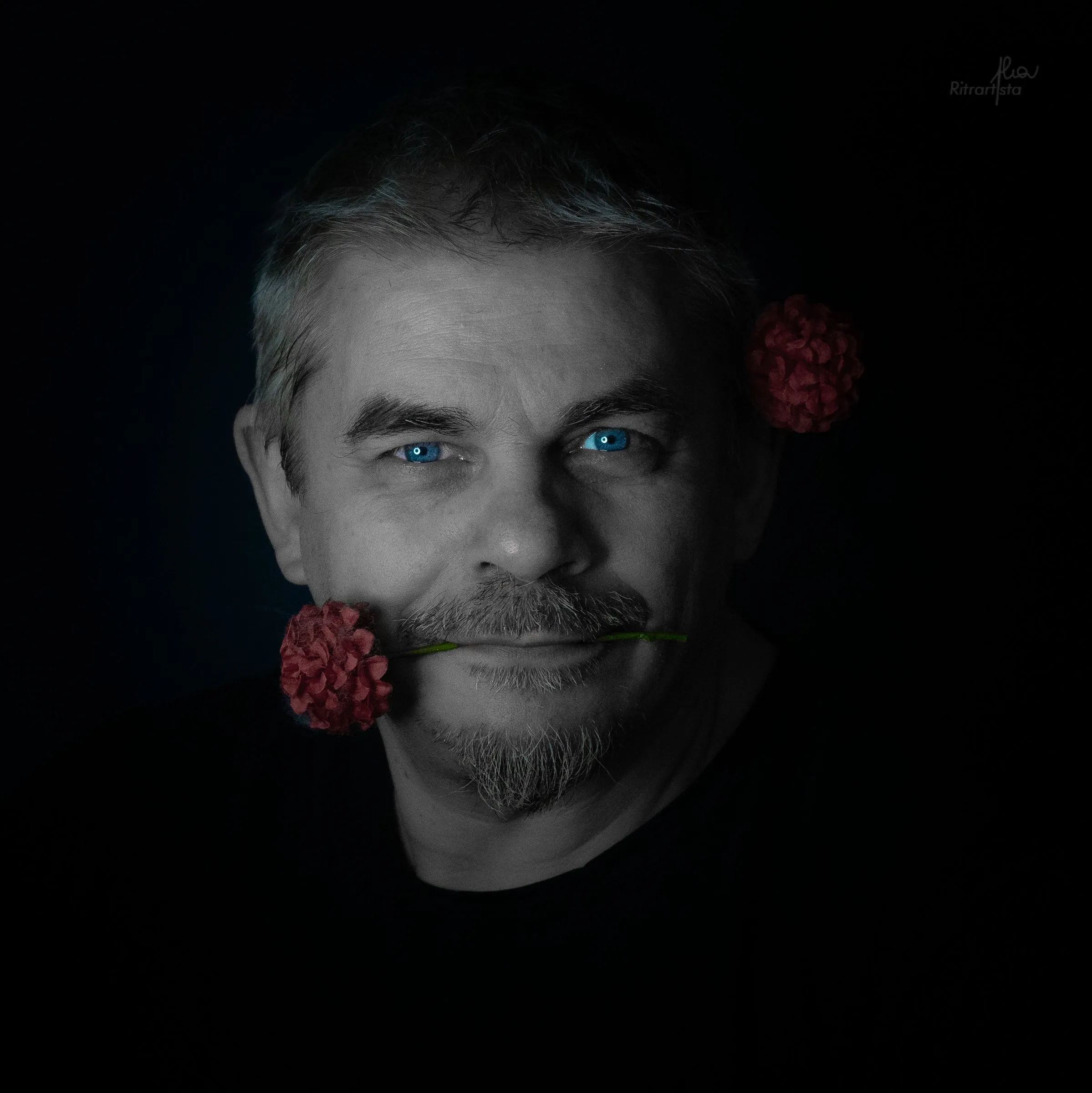 Uomo dagli occhi chiari con una rosa rossa